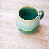 Grün-türkise Kaffeetasse von Vila Cerâmica im Ambiente